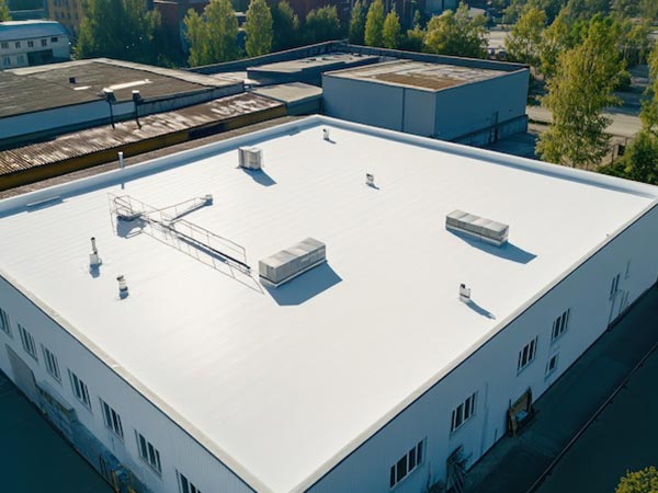 TPO-Roofing-Onalaska-WI-Wisconsin-2 | Golden Eagle Roofing Aerial view of a large white flat-roofed industrial building with HVAC units and ductwork on top of the roof.